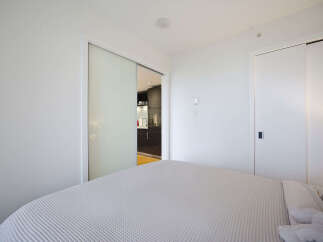 Experience modern living in this bright bedroom featuring a comfortable bed with a textured comforter.