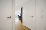 Step into this modern apartment hallway, featuring sleek white doors with brushed nickel hardware.
