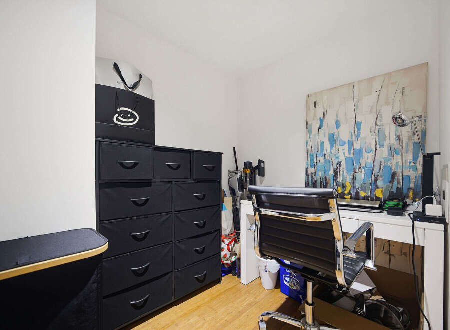 This home office features a modern black fabric drawer unit for ample storage, complemented by a sleek black office chair.