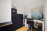 This home office features a modern black fabric drawer unit for ample storage, complemented by a sleek black office chair.