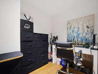 This home office features a modern black fabric drawer unit for ample storage, complemented by a sleek black office chair.