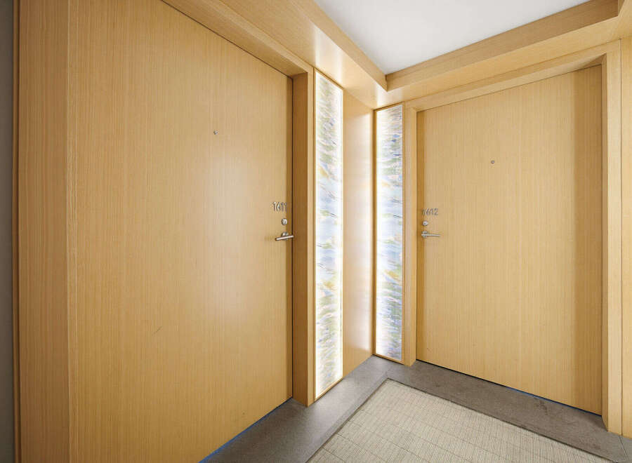 Discover modern living with these two elegant wooden doors, each featuring a sleek silver handle and discreet numbering.