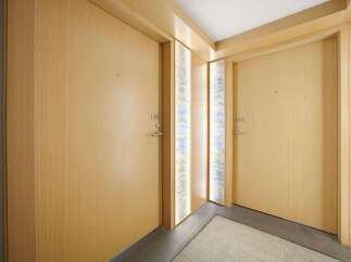 Discover modern living with these two elegant wooden doors, each featuring a sleek silver handle and discreet numbering.