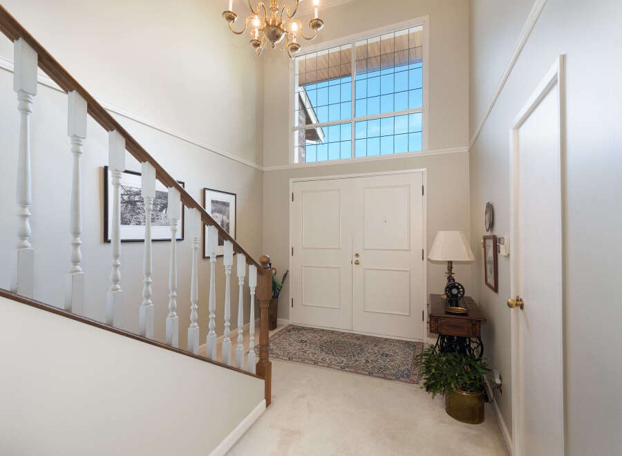 Step into this grand foyer featuring a soaring ceiling and a stunning Palladian window that floods the space with natural light.
