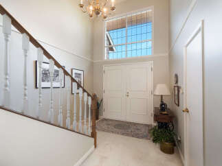 Step into this grand foyer featuring a soaring ceiling and a stunning Palladian window that floods the space with natural light.