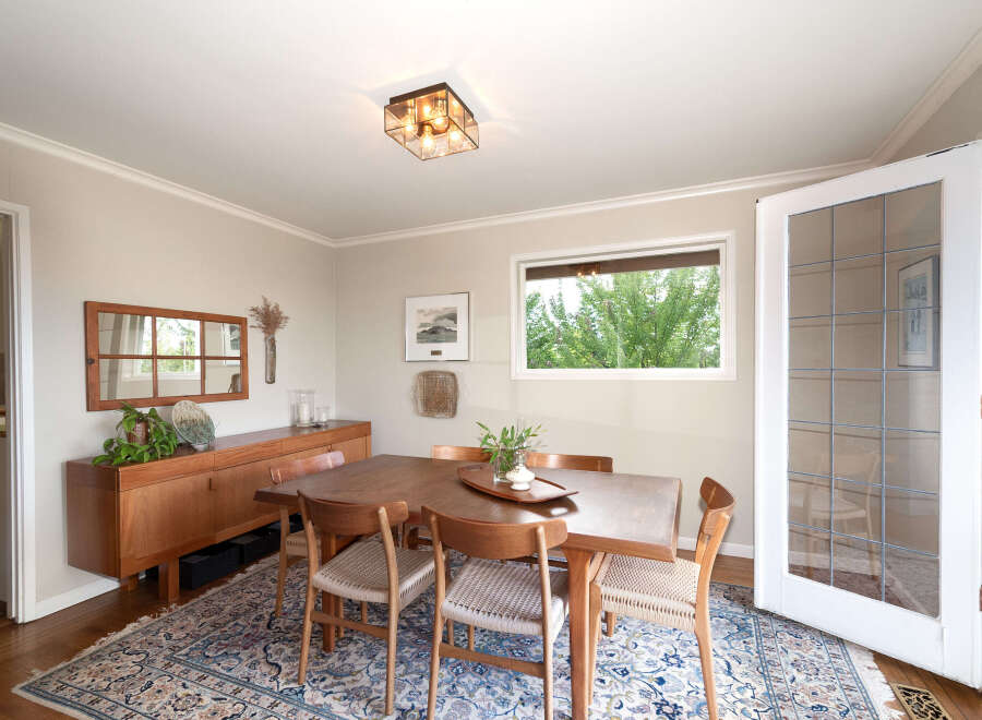 This dining room features a beautiful wooden dining table with four chairs, perfect for intimate gatherings.
