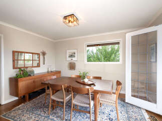 This dining room features a beautiful wooden dining table with four chairs, perfect for intimate gatherings.