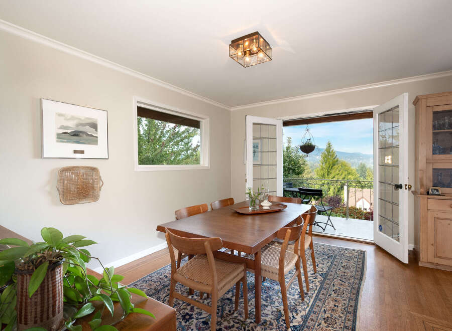 Experience breathtaking views from this charming dining room, featuring a spacious wooden table and chairs perfect for family gatherings.