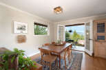 Experience breathtaking views from this charming dining room, featuring a spacious wooden table and chairs perfect for family gatherings.