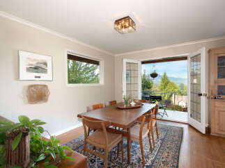 Experience breathtaking views from this charming dining room, featuring a spacious wooden table and chairs perfect for family gatherings.