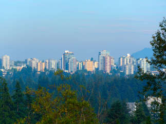 Discover modern living amidst nature with this stunning cityscape view.