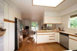 This spacious kitchen features ample cabinet space and a sleek stainless steel refrigerator.