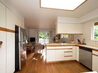 This spacious kitchen features ample cabinet space and a sleek stainless steel refrigerator.