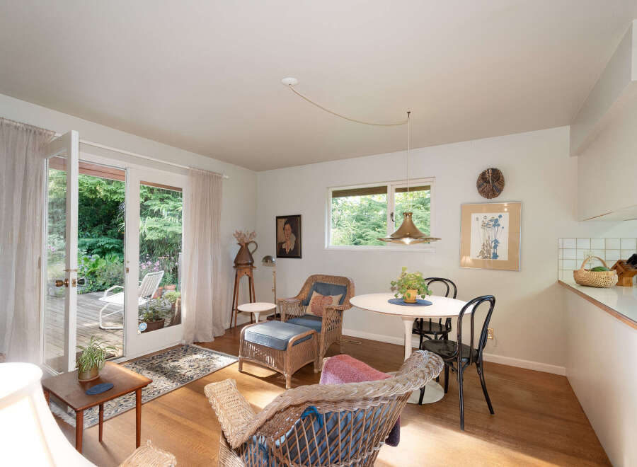 Step into this charming living space featuring a cozy seating area with wicker chairs and a dining nook perfect for intimate meals.