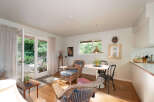 Step into this charming living space featuring a cozy seating area with wicker chairs and a dining nook perfect for intimate meals.