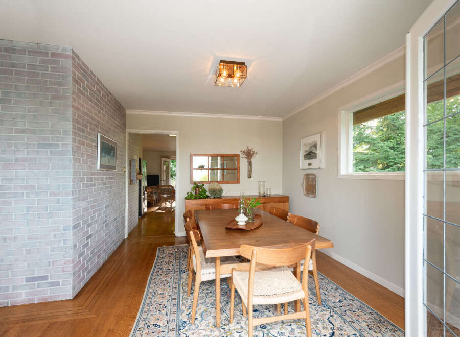 This dining room features a beautiful wooden dining table with four chairs, set on an ornate rug.