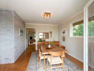 This dining room features a beautiful wooden dining table with four chairs, set on an ornate rug.