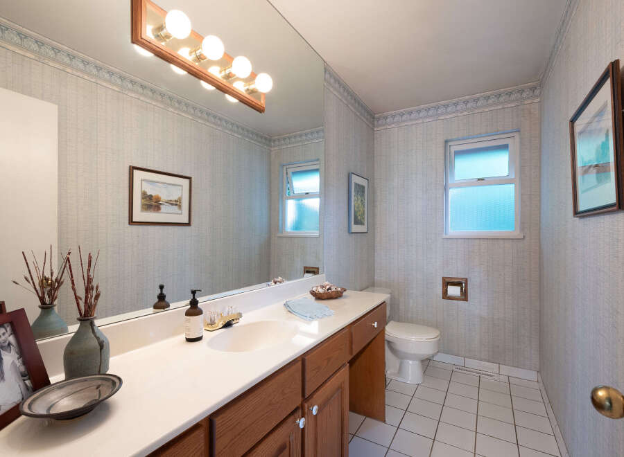 This charming bathroom features a spacious vanity with a double sink and ample counter space, perfect for morning routines.