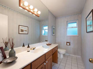 This charming bathroom features a spacious vanity with a double sink and ample counter space, perfect for morning routines.