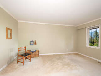 This spacious room features a large window offering picturesque views of lush greenery and mountains.
