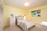 Discover comfort and style in this charming bedroom, featuring a cozy queen-size bed with a decorative metal headboard and a light-colored duvet.