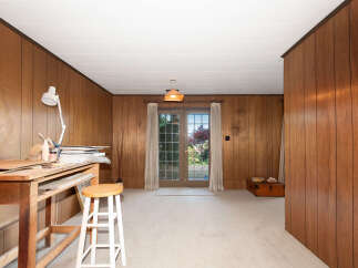 Discover a versatile space with warm wood paneling and a bright, airy feel, perfect for an art studio or creative retreat.