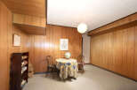 Step into a retro-inspired living space featuring warm wood paneling throughout, creating a cozy and inviting atmosphere.