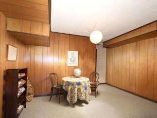 Step into a retro-inspired living space featuring warm wood paneling throughout, creating a cozy and inviting atmosphere.