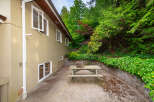 Enjoy outdoor living with this charming picnic table set in a lush, green backyard.