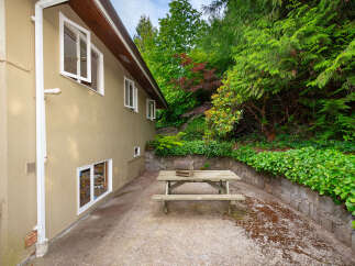 Enjoy outdoor living with this charming picnic table set in a lush, green backyard.
