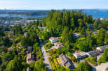 Discover this stunning aerial view of a lush, green neighborhood with beautiful homes nestled among mature trees.