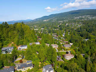 Nestled amidst lush greenery, this stunning property offers breathtaking views of the surrounding mountains and water.