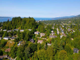 Experience breathtaking views from this stunning hillside property, nestled amidst lush greenery and mature trees.
