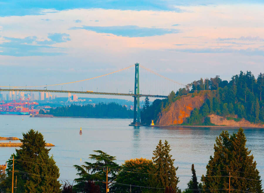 Experience breathtaking views from this prime location, featuring a majestic suspension bridge and a vibrant cityscape in the distance.