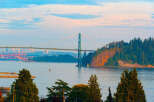 Experience breathtaking views from this prime location, featuring a majestic suspension bridge and a vibrant cityscape in the distance.