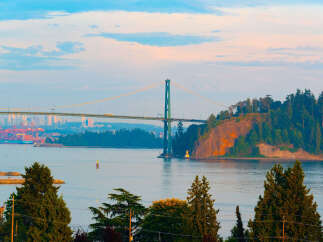 Experience breathtaking views from this prime location, featuring a majestic suspension bridge and a vibrant cityscape in the distance.
