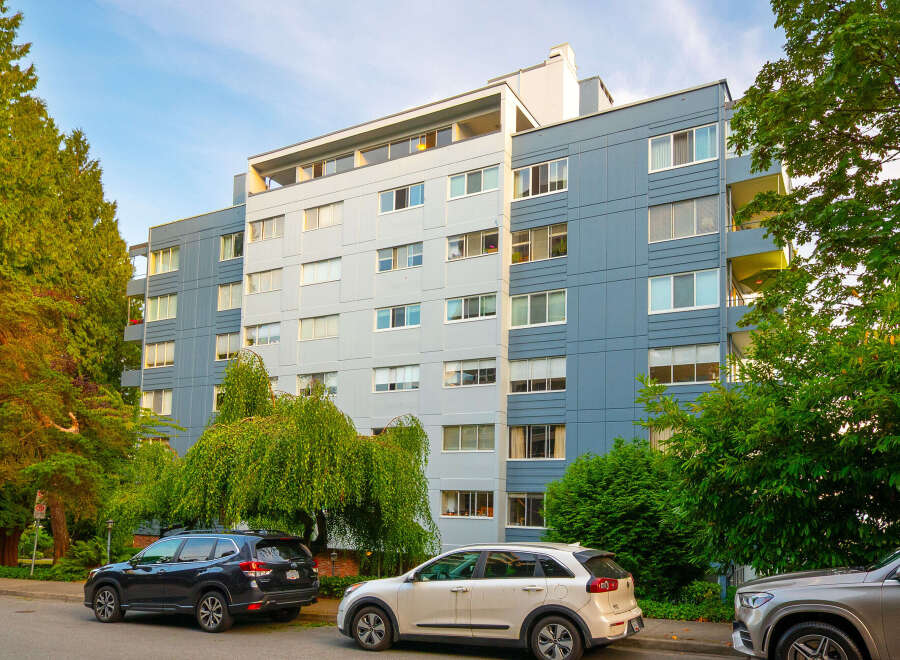 Discover modern urban living in this multi-story apartment building, featuring a striking facade of blue and light gray panels.