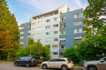 Discover modern urban living in this multi-story apartment building, featuring a striking facade of blue and light gray panels.