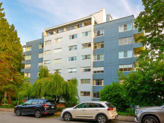 Discover modern urban living in this multi-story apartment building, featuring a striking facade of blue and light gray panels.