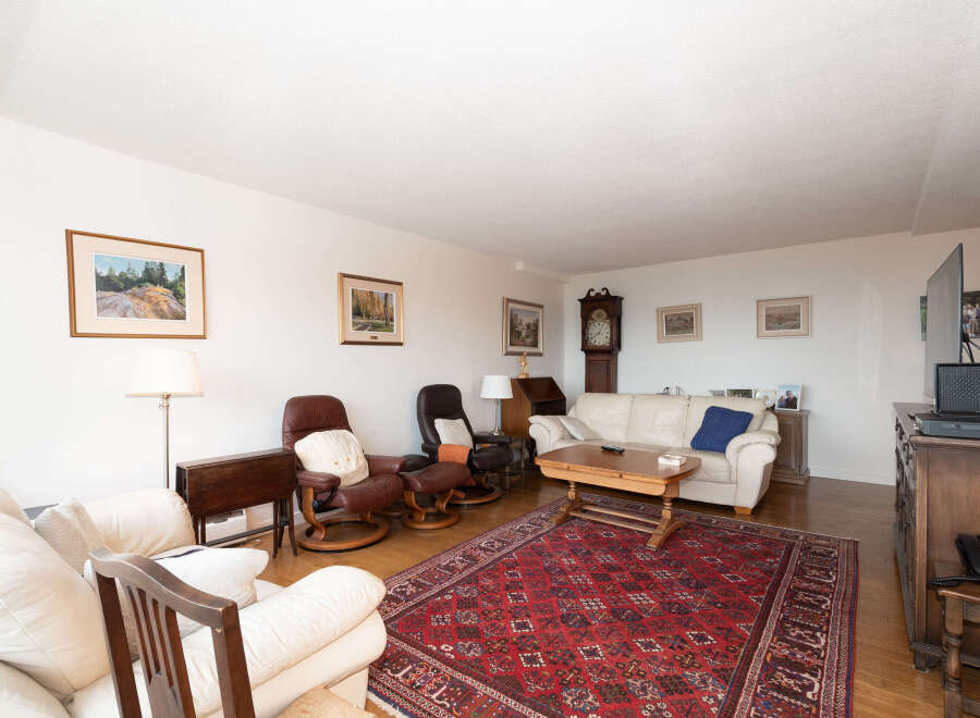 Step into this inviting living room, featuring a plush white sofa and comfortable leather recliners perfect for relaxation.