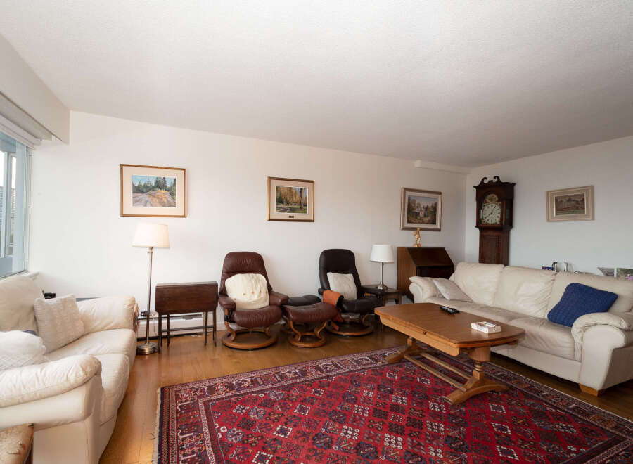 Step into this inviting living room, featuring plush cream-colored sofas and comfortable leather recliners perfect for relaxation.