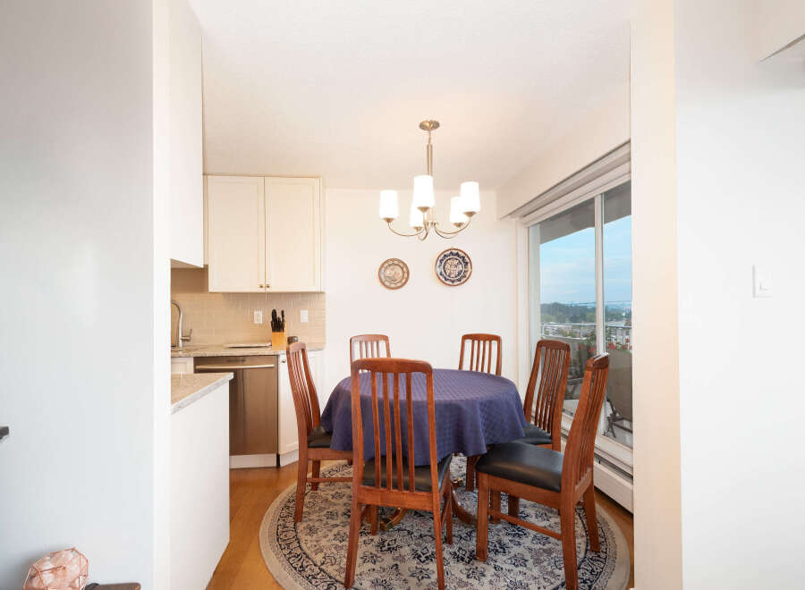 Enjoy meals with loved ones in this charming dining area, featuring a round table draped in a deep blue tablecloth and surrounded by classic wooden chairs.