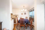 Enjoy meals with loved ones in this charming dining area, featuring a round table draped in a deep blue tablecloth and surrounded by classic wooden chairs.