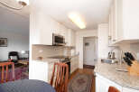 This bright and airy kitchen features sleek white cabinetry, granite countertops, and a modern subway tile backsplash.