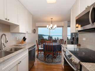 Enjoy breathtaking water views from this charming kitchen and dining area, perfect for entertaining.