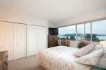 Wake up to breathtaking water and bridge views from this serene bedroom.