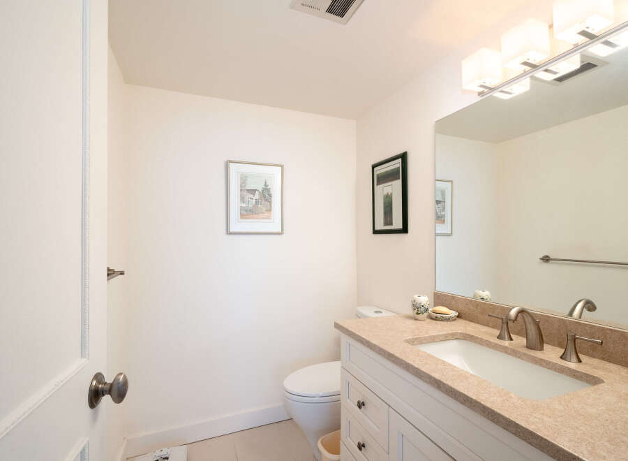 This charming bathroom features a modern vanity with a granite countertop and a sleek undermount sink, complemented by brushed nickel fixtures.