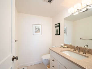 This charming bathroom features a modern vanity with a granite countertop and a sleek undermount sink, complemented by brushed nickel fixtures.