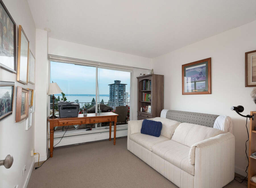 Enjoy stunning water views from this bright living space, featuring a comfortable sofa and a dedicated workspace by the large window.