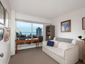 Enjoy stunning water views from this bright living space, featuring a comfortable sofa and a dedicated workspace by the large window.